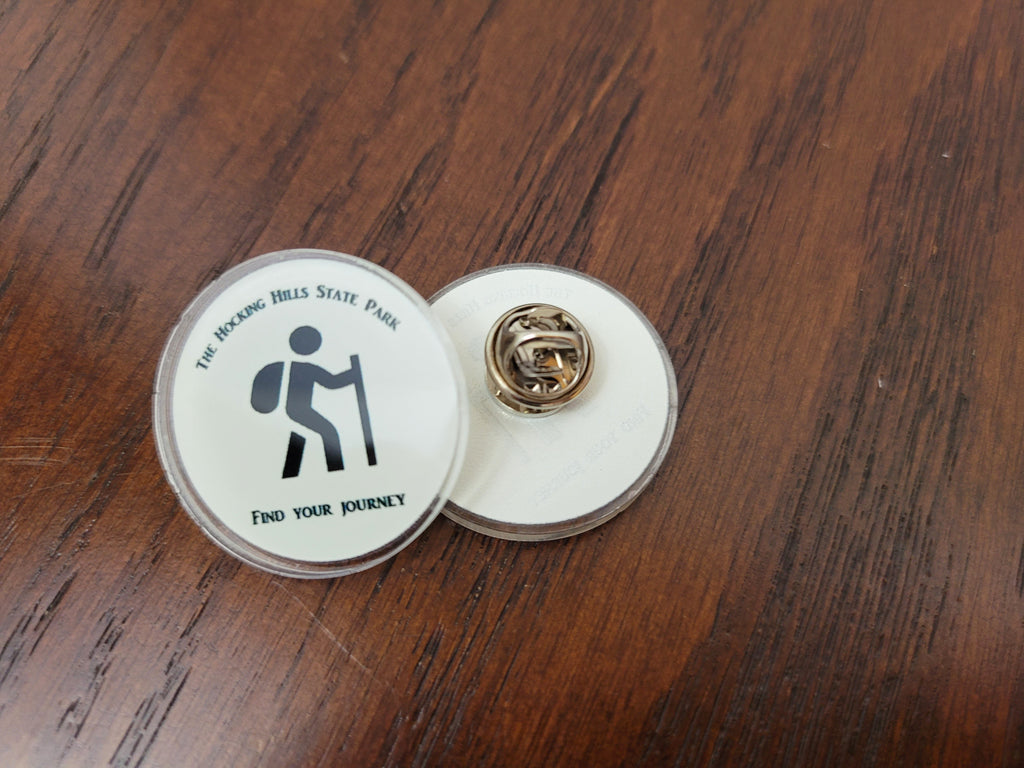 The Hocking Hills Store collector pin featuring a hiker icon and the phrase "find your journey".