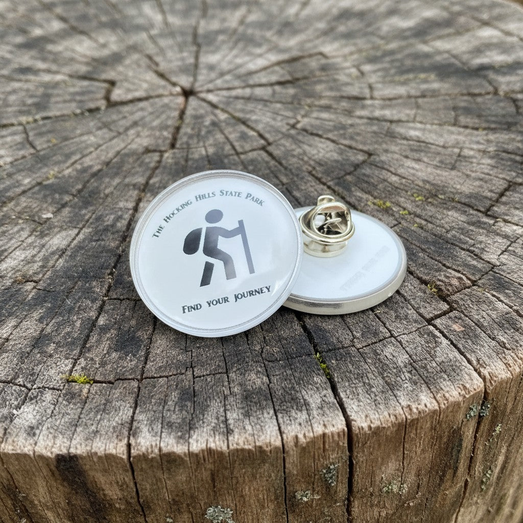The Hocking Hills Store collector pin with hiker graphic and "find your journey" text.