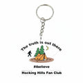The Hocking Hills Store keychain with Bigfoot, tent, trees, and moon graphic. Features text 'The truth is out there', '#ibelieve', and 'Hocking Hills Fan Club'.