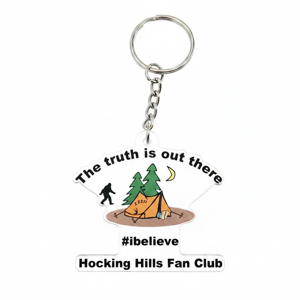 The Hocking Hills Store keychain with Bigfoot, tent, trees, and moon graphic. Features text 'The truth is out there', '#ibelieve', and 'Hocking Hills Fan Club'.