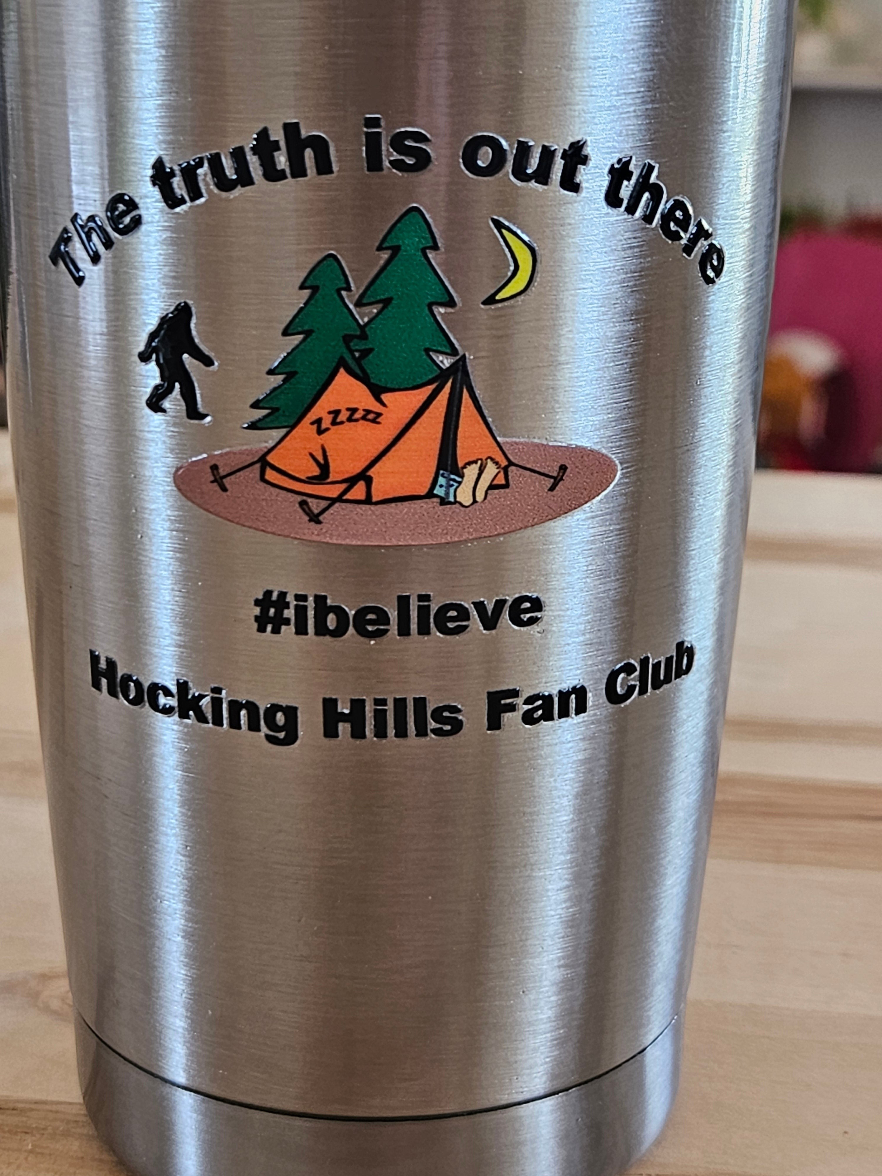 The Hocking Hills Store 20 oz stainless steel tumbler with Bigfoot, tent, trees, and moon graphic. "The truth is out there #ibelieve Hocking Hills Fan Club" text.