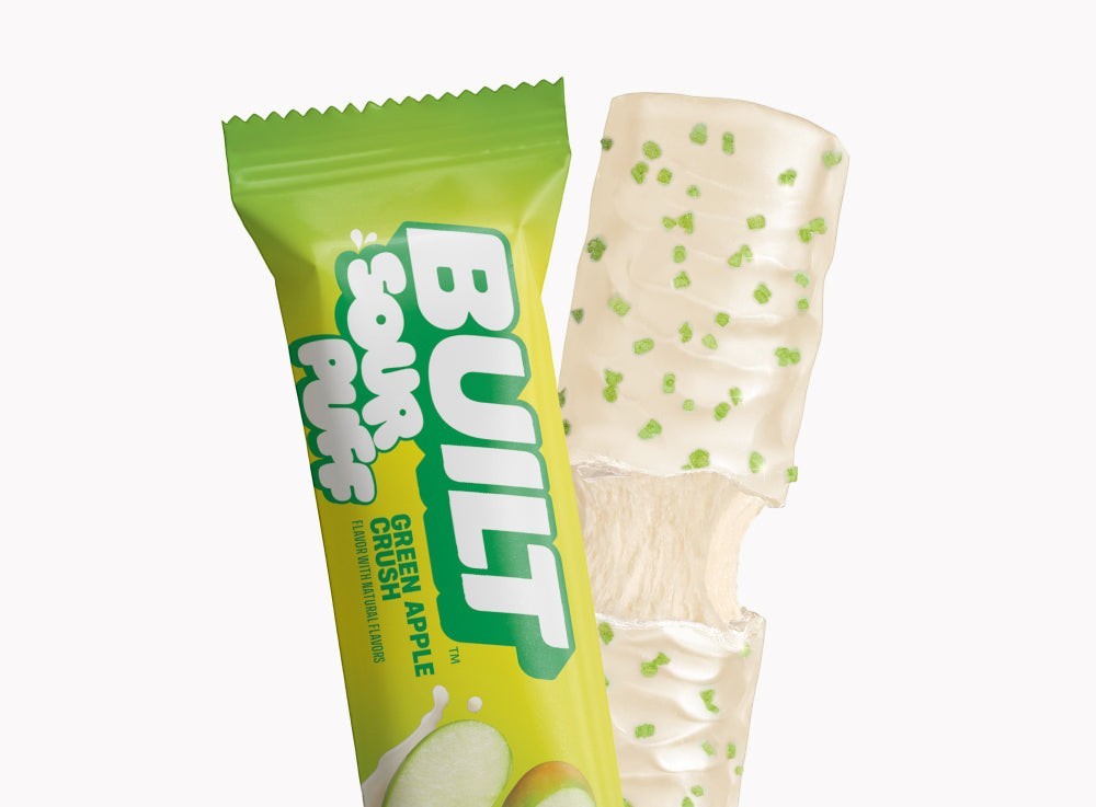 The Hocking Hills Store Green Apple Crush Sour Puff bar with white coating and green sprinkles, next to its green packaging.