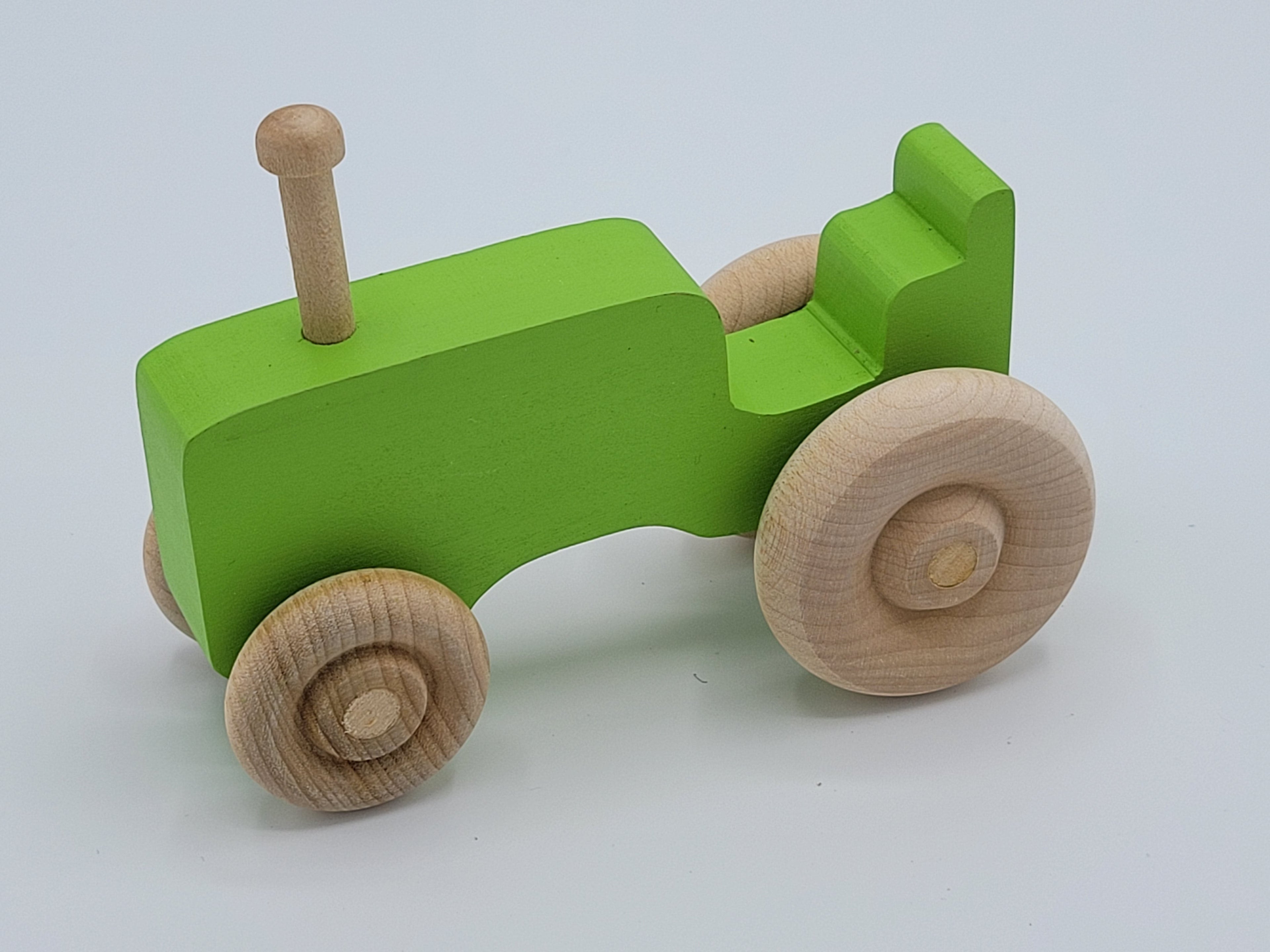 The Hocking Hills Store handmade green wooden toy tractor with natural wood wheels and steering column.