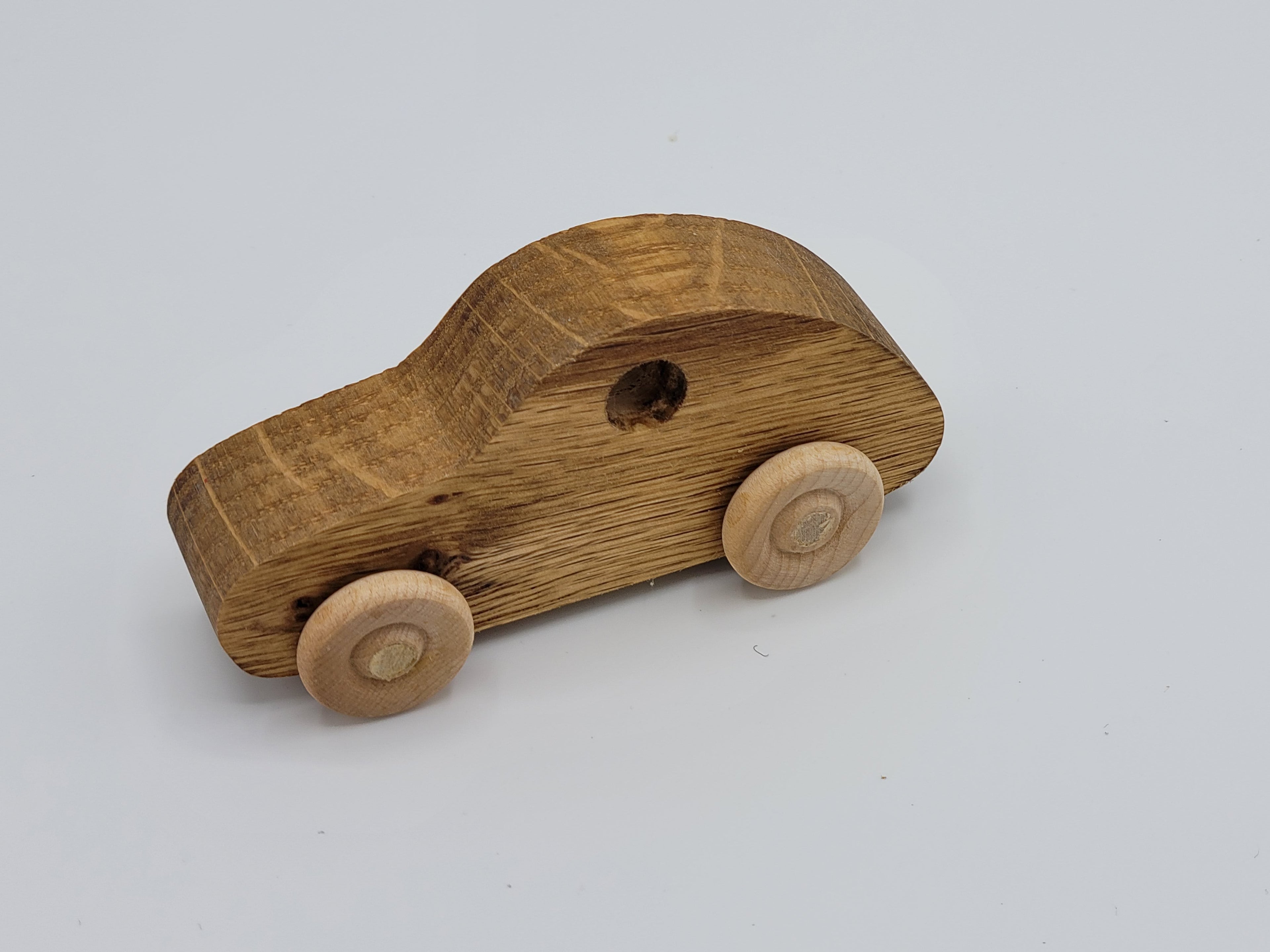The Hocking Hills Store handmade wooden toy car, natural wood finish, simple design with wooden wheels.