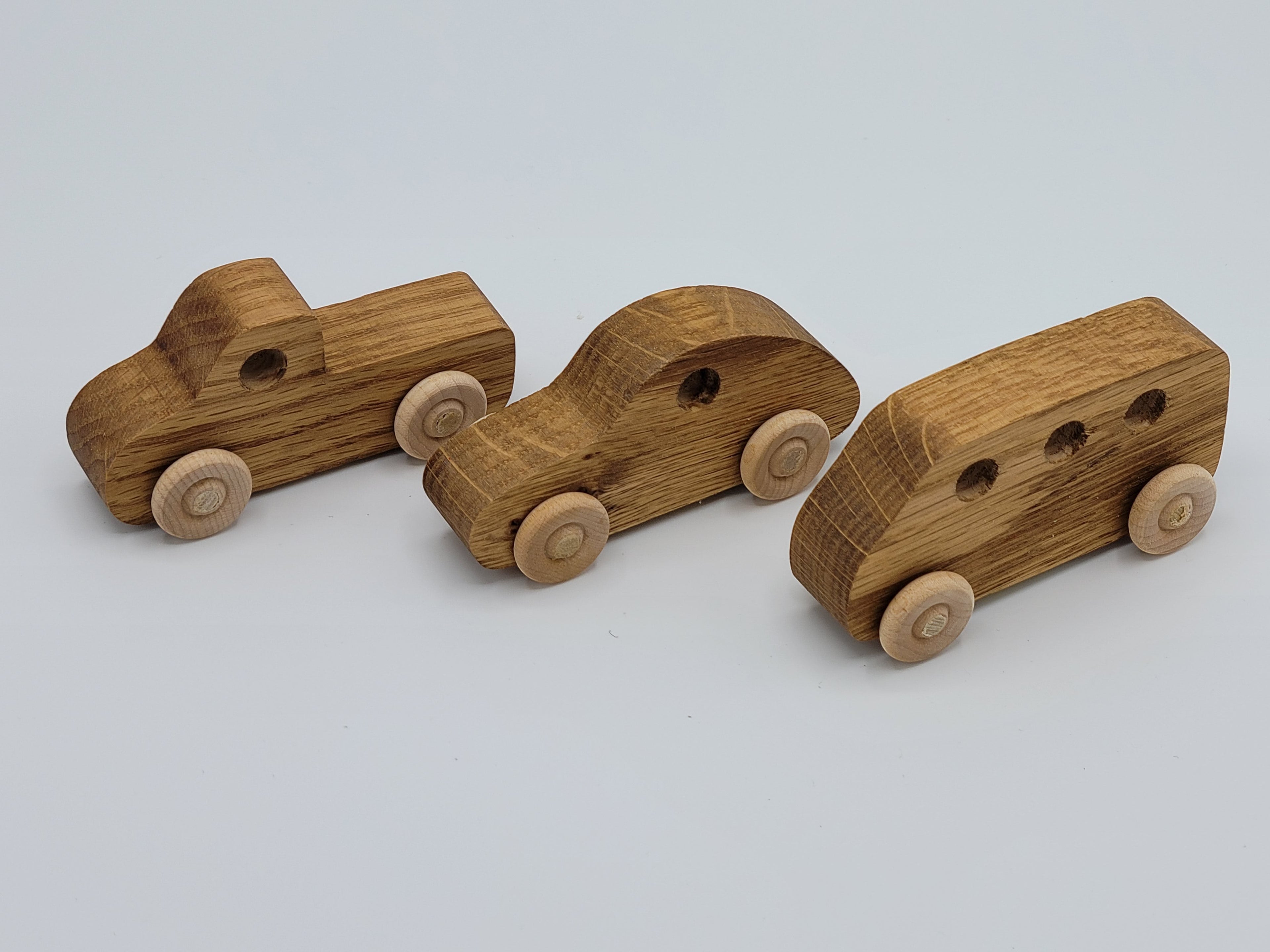 The Hocking Hills Store handmade wooden cars set includes a pickup truck, sedan, and van. Natural wood finish.