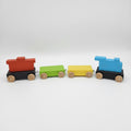 The Hocking Hills Store handmade wooden toy train with red, green, yellow, and blue carriages on black bases with wooden wheels.