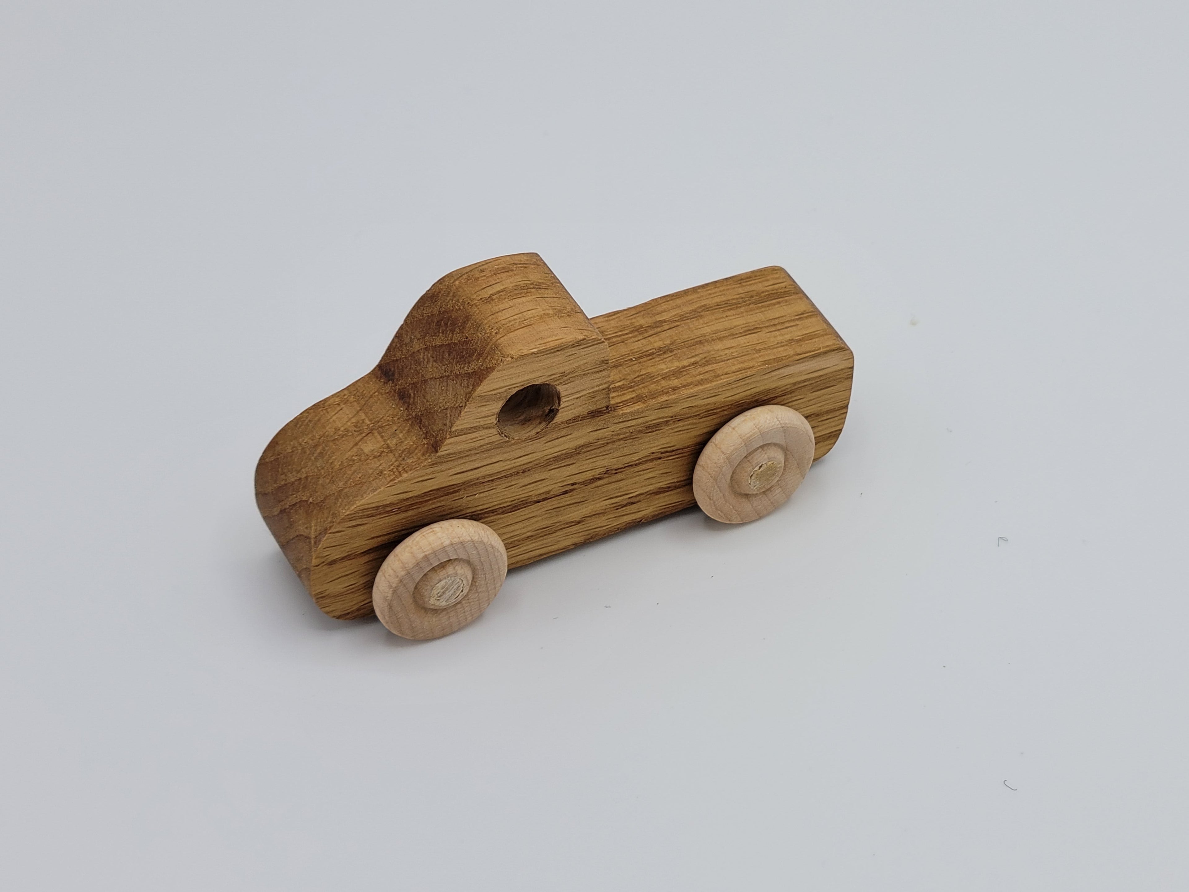 The Hocking Hills Store handmade wooden pickup truck toy with natural wood grain and light wood wheels.