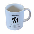 The Hocking Hills Store white ceramic mug with black text and hiker graphic. "Find your journey" text above hiker.