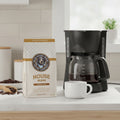 The Hocking Hills Store House Blend medium roast 100% Arabica coffee bag with tasting notes of milk chocolate, toasted almonds, and orange.