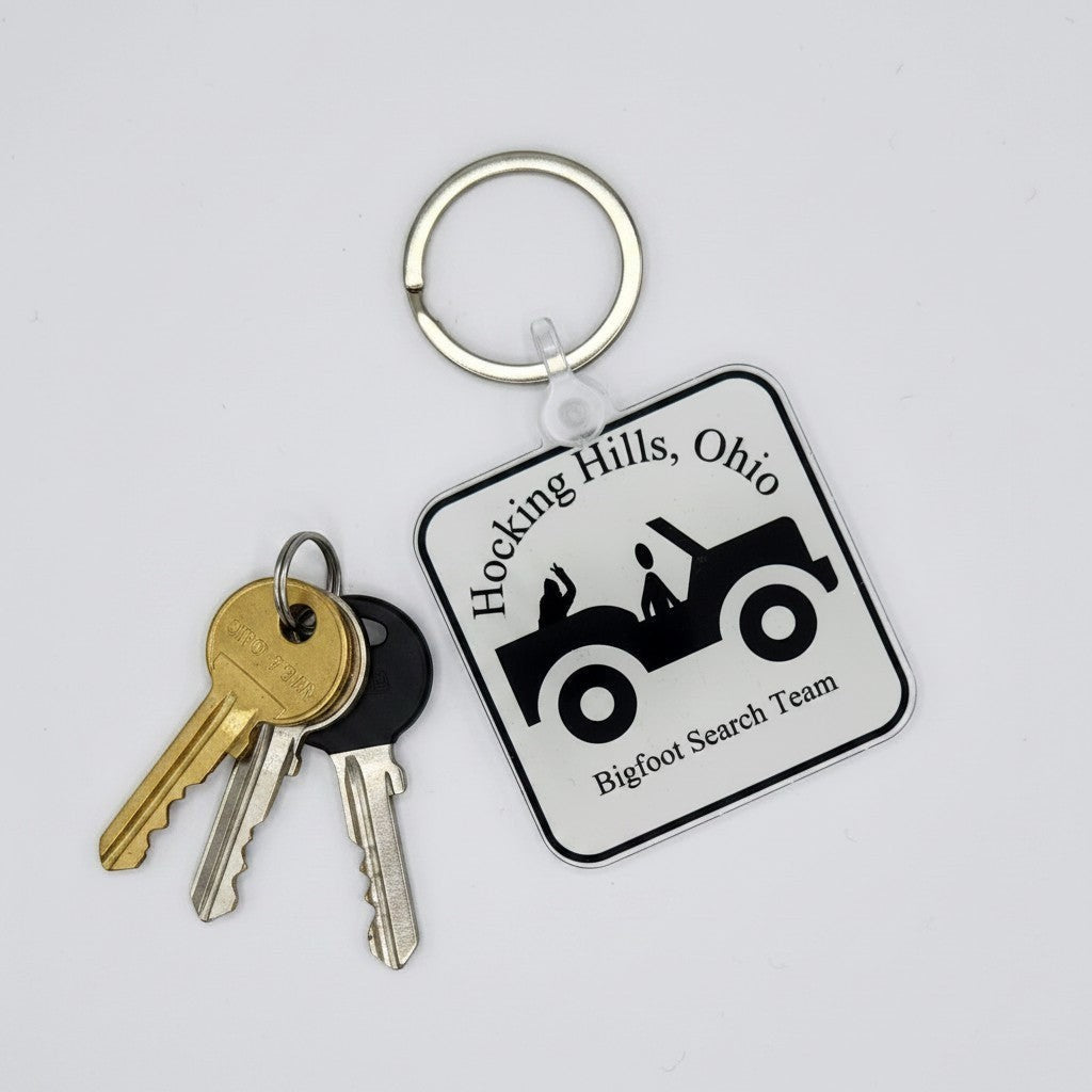 The Hocking Hills Store Jeep Bigfoot Search Team keychain features a black jeep graphic with text. Silver keyring attached.