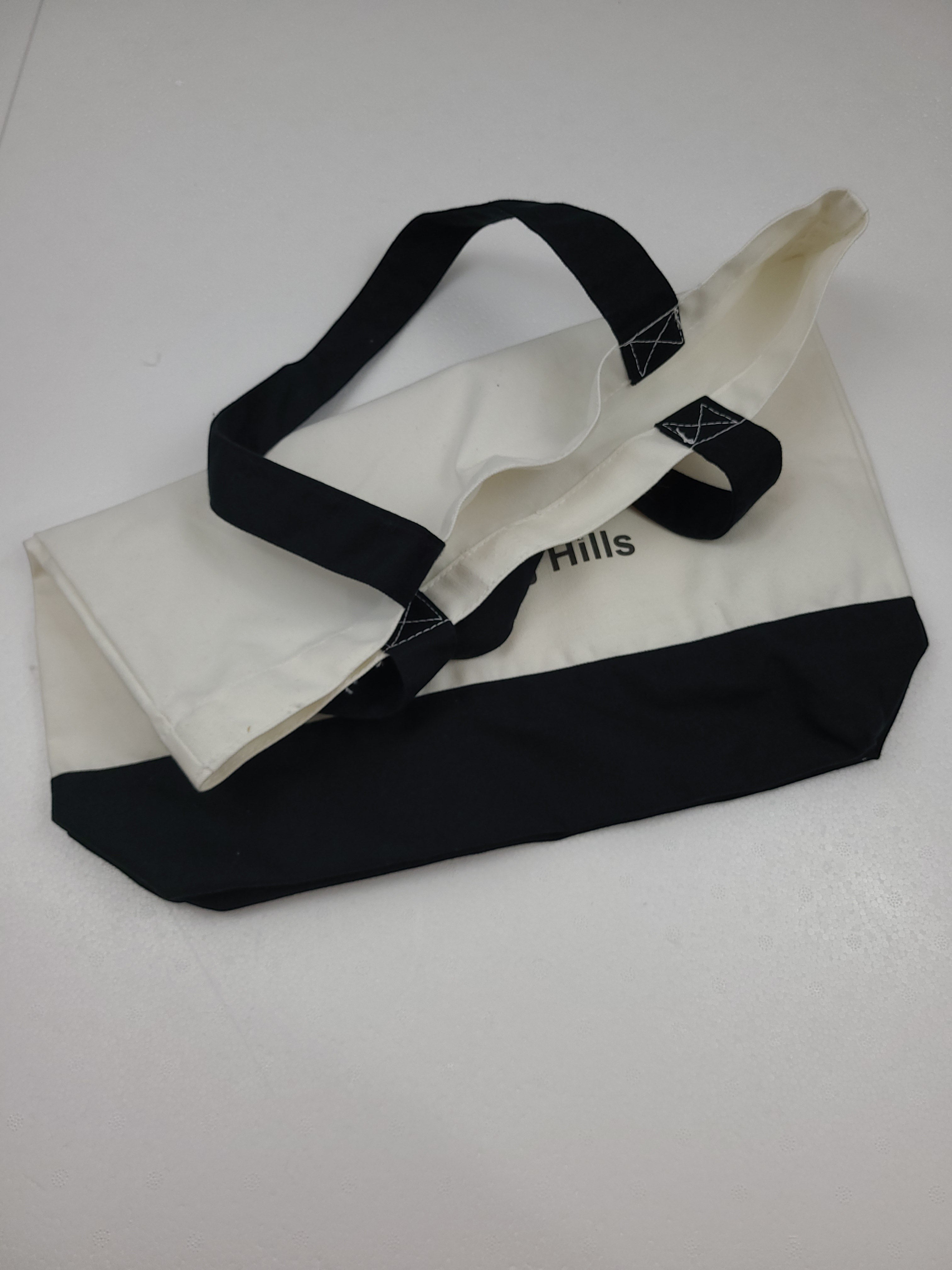 The Hocking Hills Store large two-tone cloth tote bag in white and black with black handles.