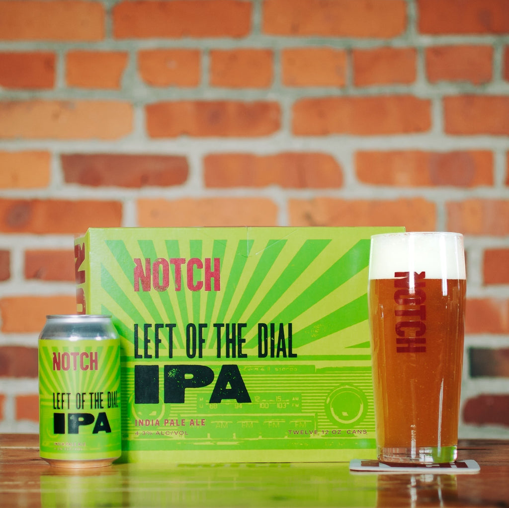 The Hocking Hills Store Left of the Dial IPA beer can and pint glass with a 12-pack box in the background.