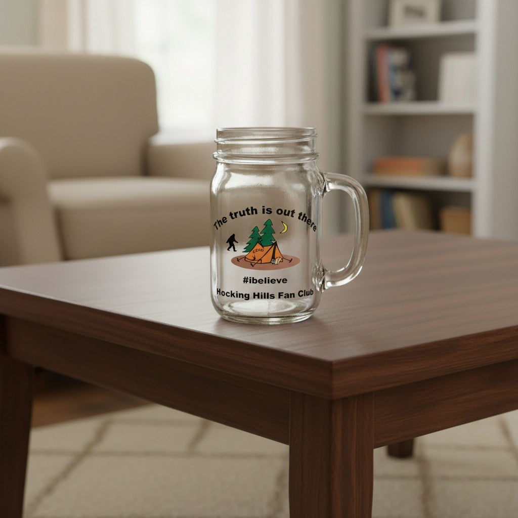 The Hocking Hills Store clear glass mason jar mug with Bigfoot, tent, and trees graphic. Features text 'The truth is out there' and '#ibelieve Hocking Hills Fan Club'.