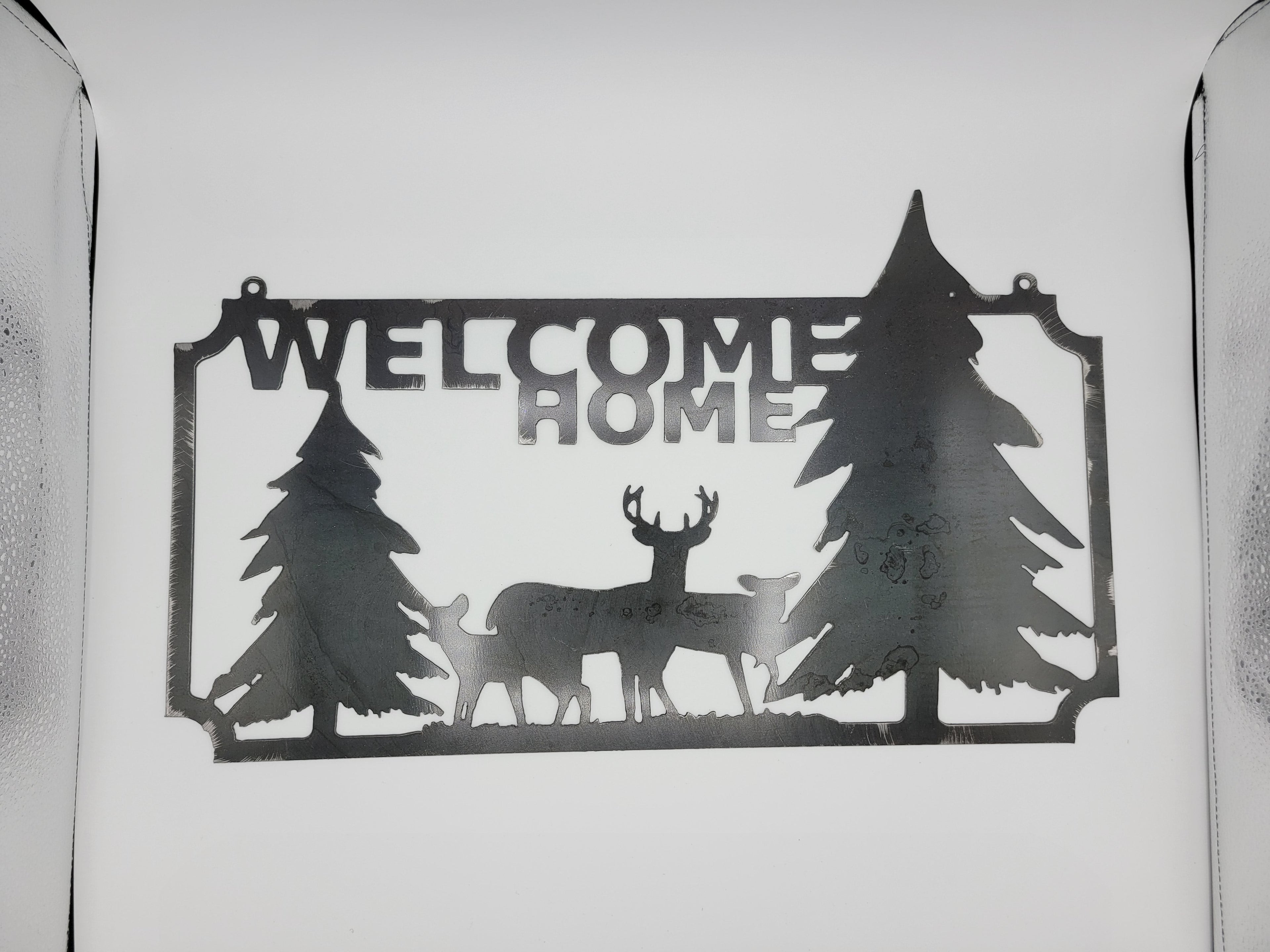 The Hocking Hills Store metal welcome home sign with deer and pine trees. Black metal.