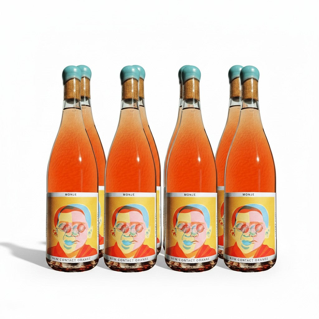 Three bottles of The Hocking Hills Store Monje orange wine with colourful, abstract portrait labels and turquoise stoppers.
