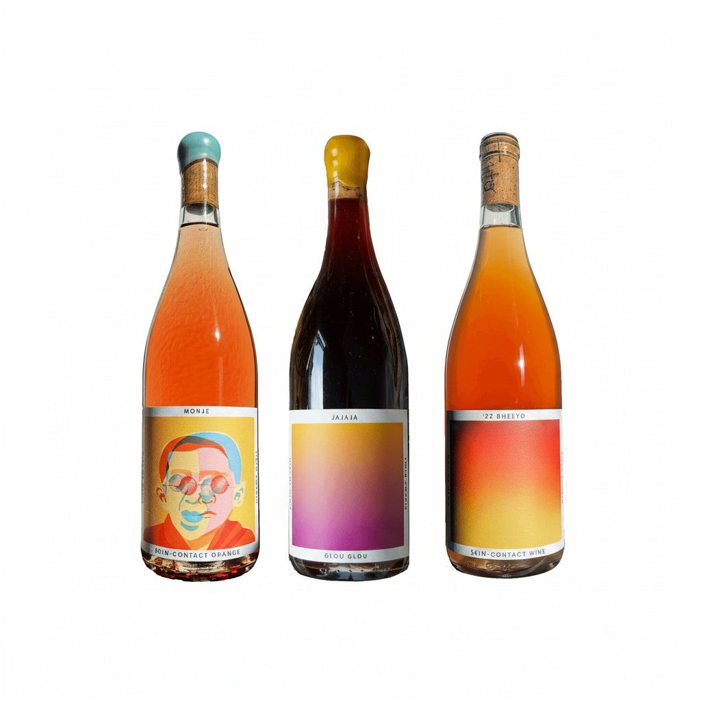 The Hocking Hills Store Natural Wine Sampler: Jajaja Glou Glou Red, Bheeyo Skin-Contact Orange, and Monje Orange Wine bottles.