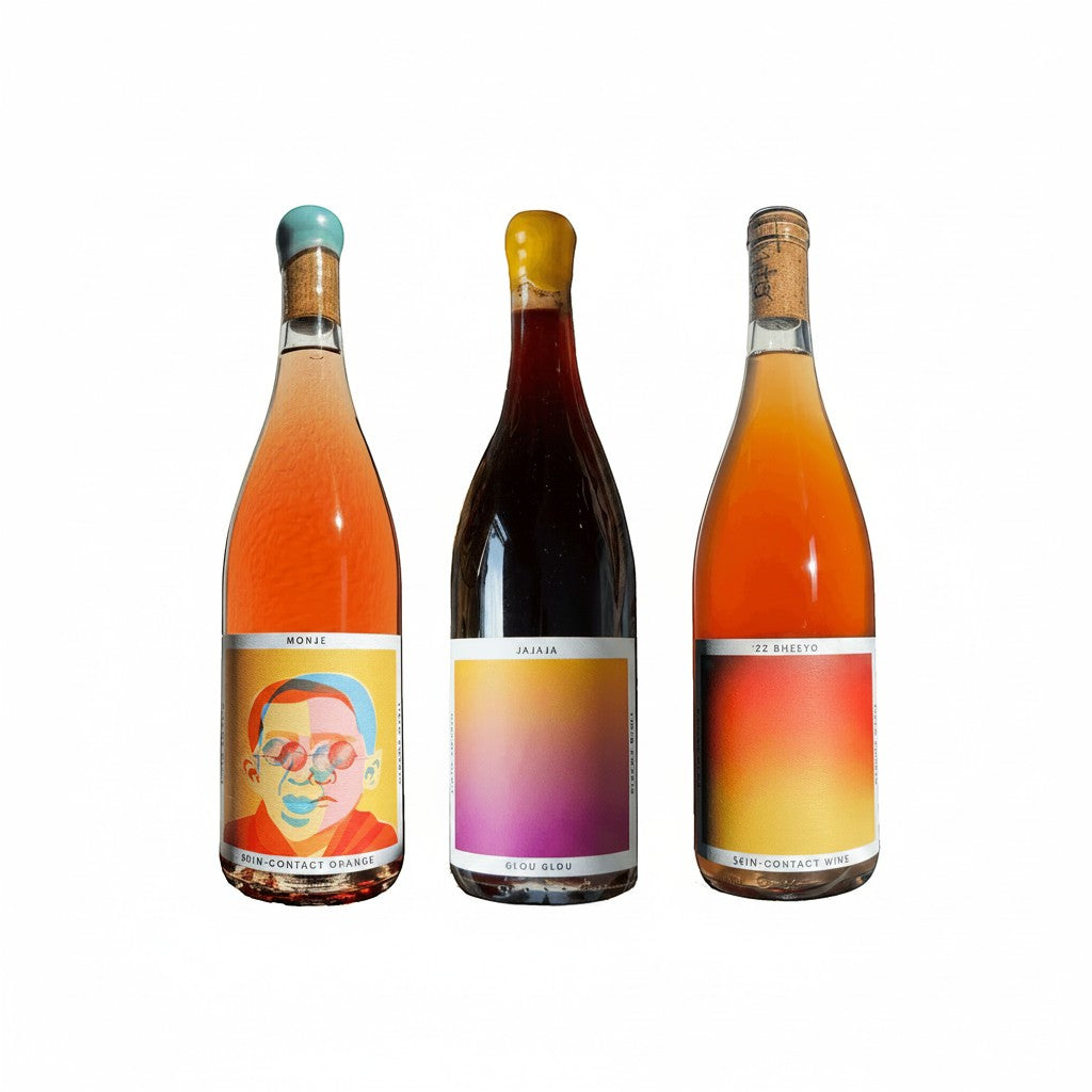 The Hocking Hills Store natural wine sampler featuring three bottles: Monje Skin-Contact Orange, Jajaja Glou Glou Red, and Bheeyo Skin-Contact Orange wine.