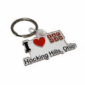 The Hocking Hills Store keychain shaped like Ohio, featuring 'I Love Hocking Hills, Ohio' text, a red heart, and icons for camping, hiking, and canoeing.