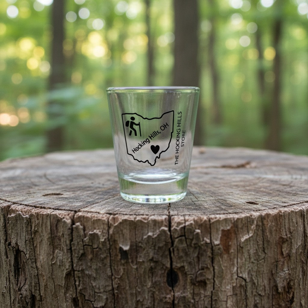 The Hocking Hills Store Ohio shot glass featuring a hiker icon and "Hocking Hills, OH" text. Clear glass.