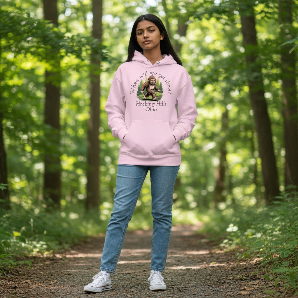 The Hocking Hills Store pink youth hoodie with a Bigfoot graphic and "When Will We Get There? Hocking Hills Ohio" text.