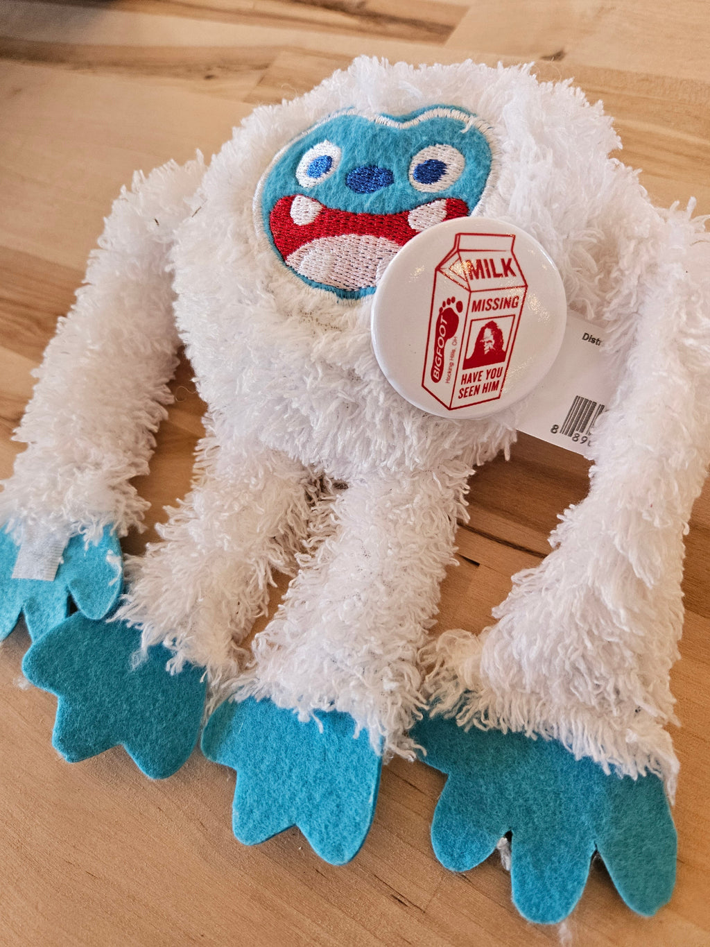 The Hocking Hills Store white plush Bigfoot with blue feet and face, wearing a Bigfoot milk carton pin.