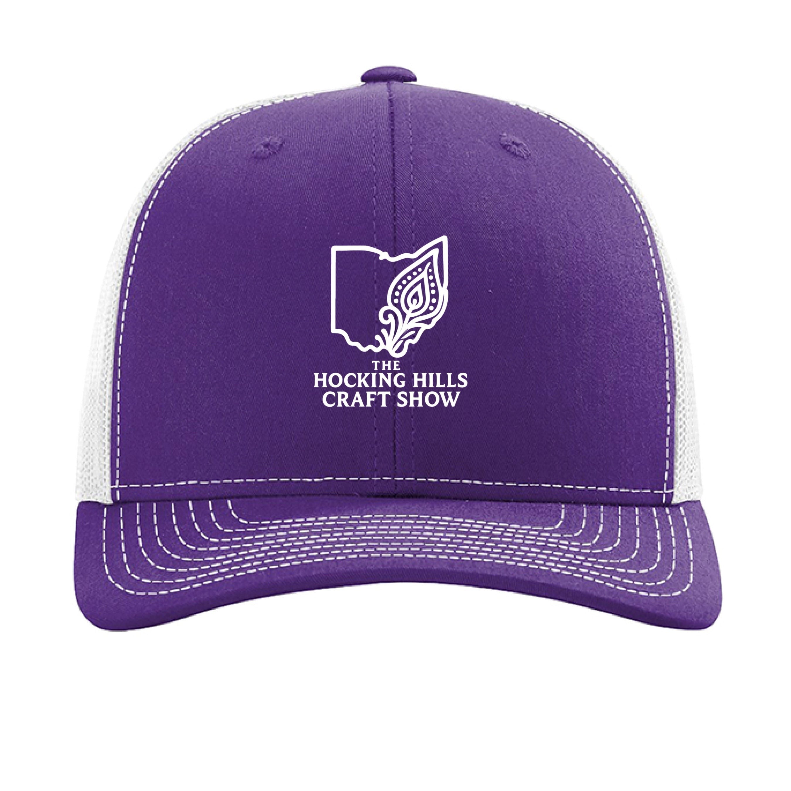The Hocking Hills Store purple and white trucker hat with "The Hocking Hills Craft Show" logo. Features a mesh back and adjustable snapback.