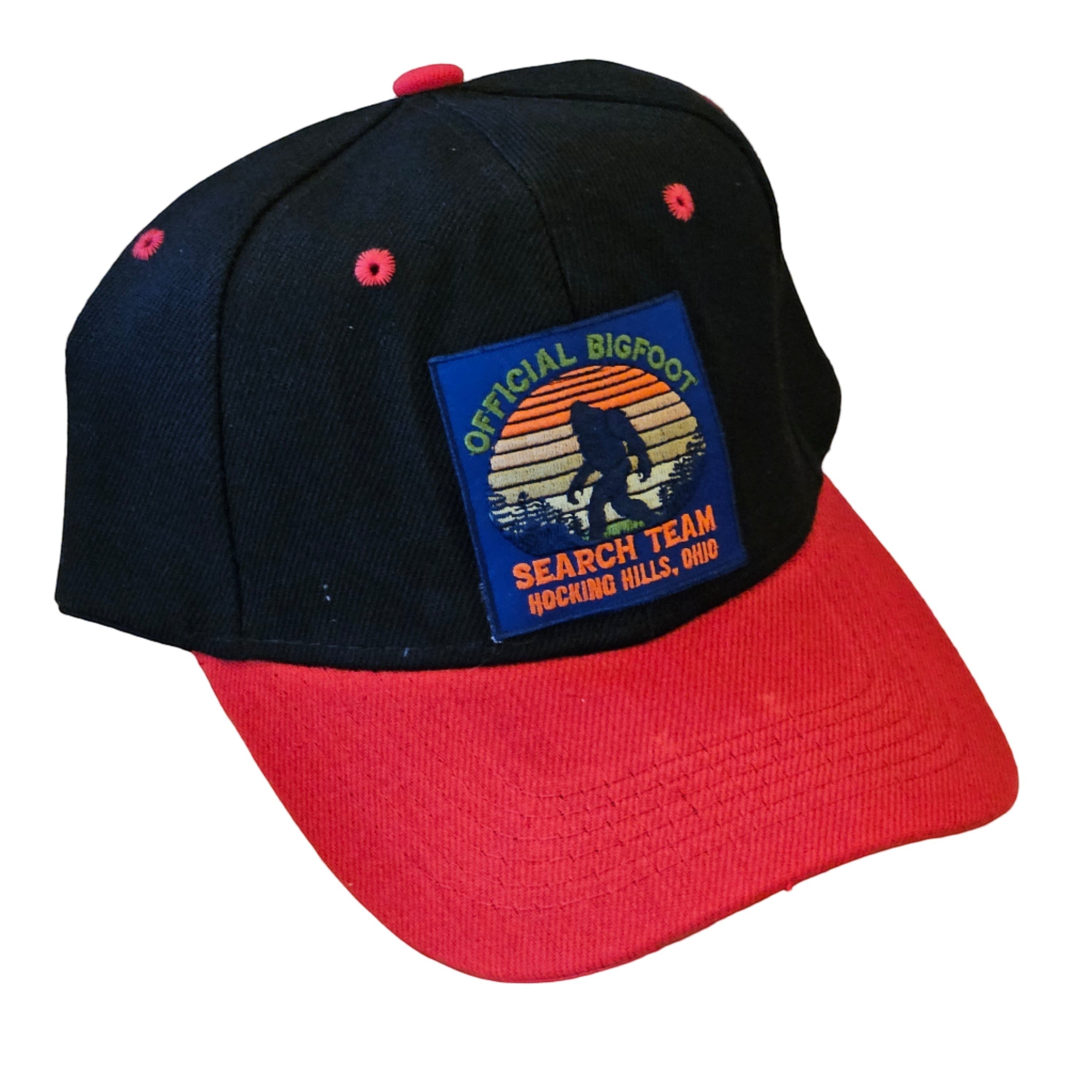 The Hocking Hills Store black and red baseball cap with a Bigfoot patch. Features a color-blocked design and embroidered details.