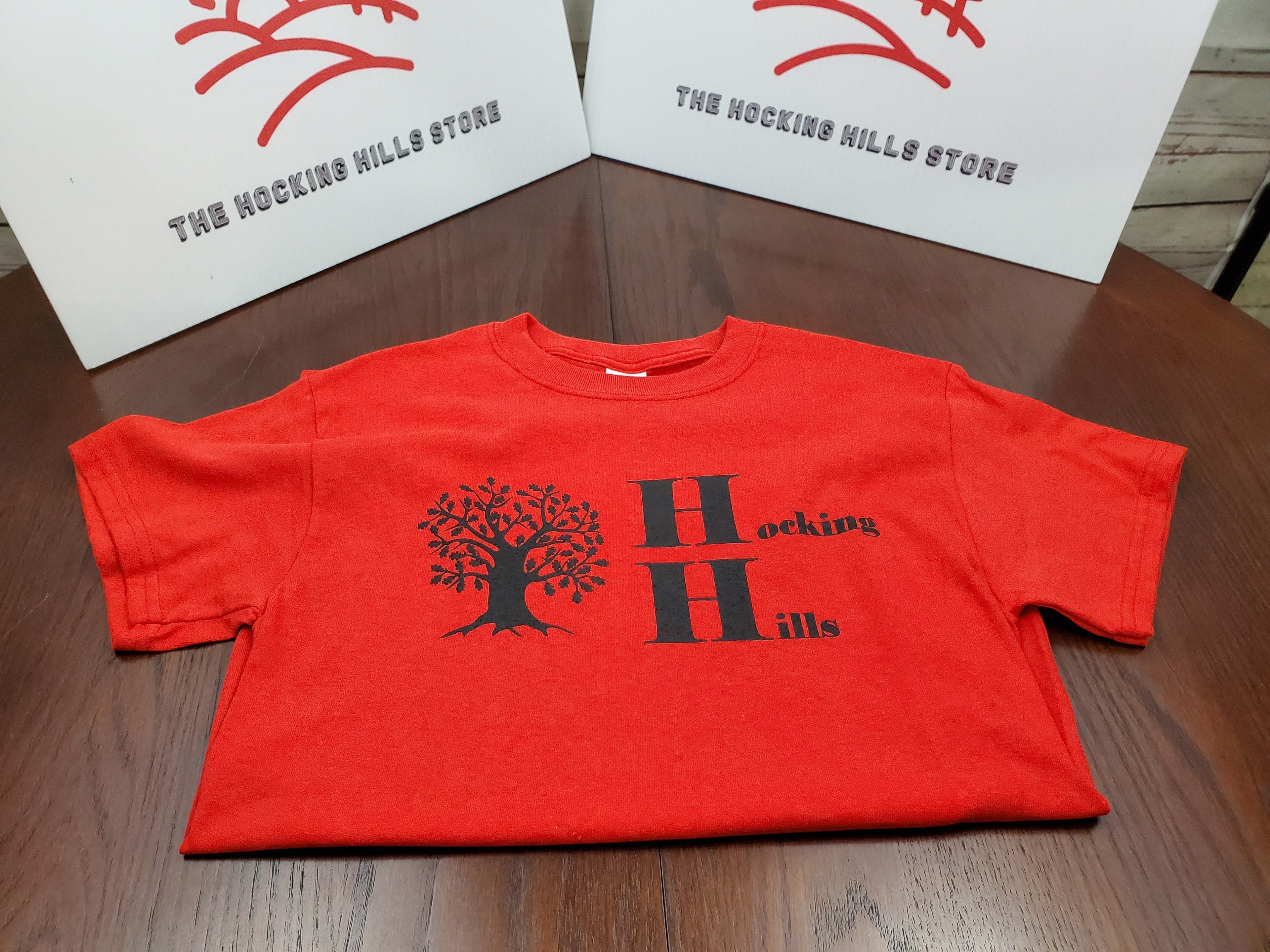 The Hocking Hills Store red cotton t-shirt with black tree and Hocking Hills logo. Short sleeves, crew neck.