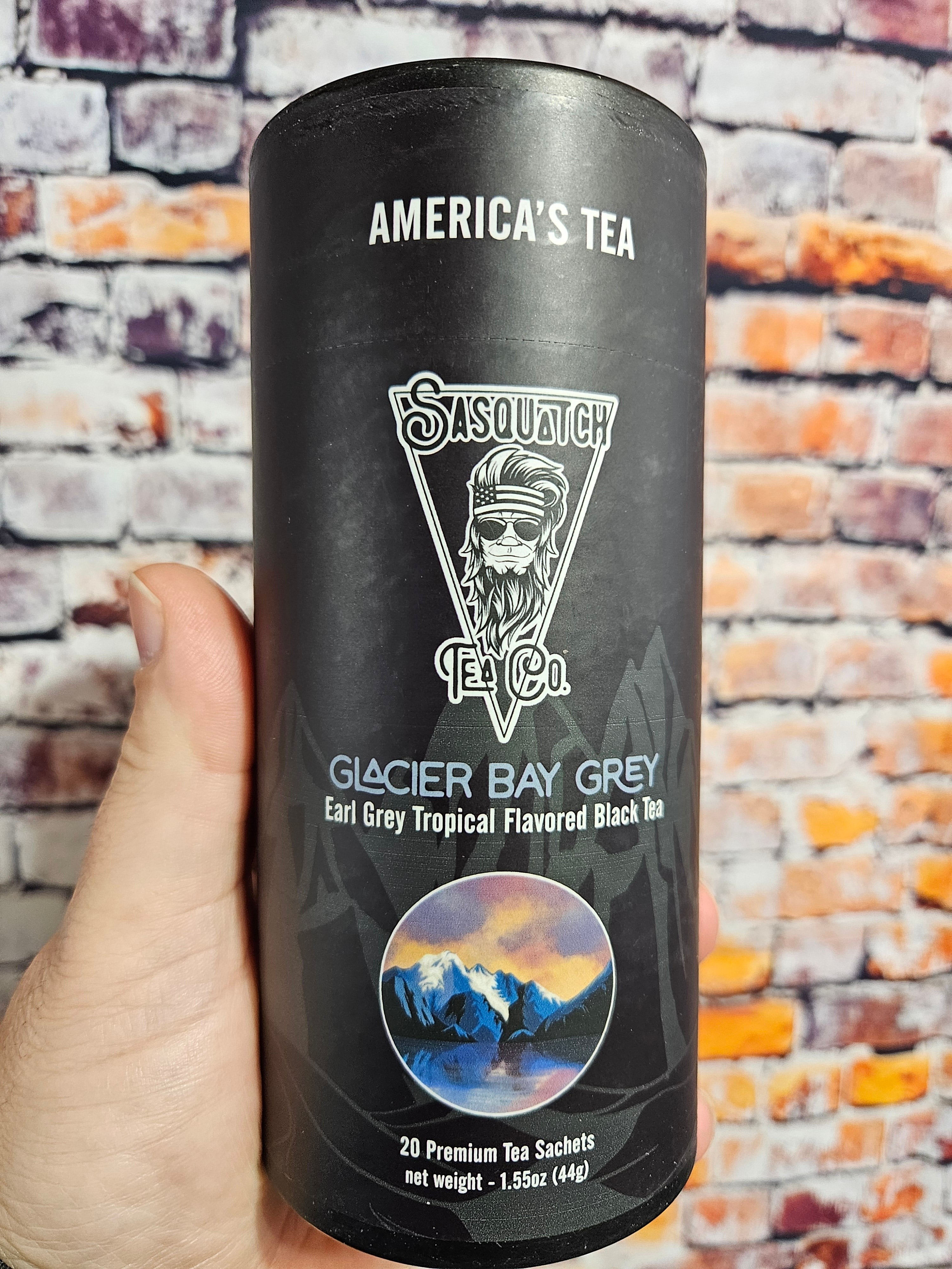 The Hocking Hills Store Sasquatch Tea Co. Glacier Bay Grey Earl Grey Tropical Flavored Black Tea in a black cylinder with a mountain landscape.