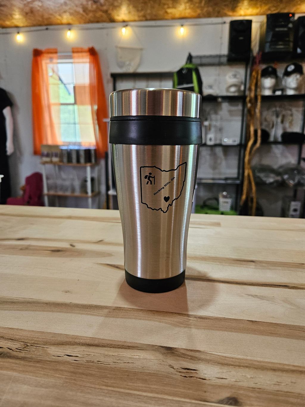 The Hocking Hills Store stainless steel travel mug with black grip and Ohio outline graphic. Perfect for hot or cold beverages.