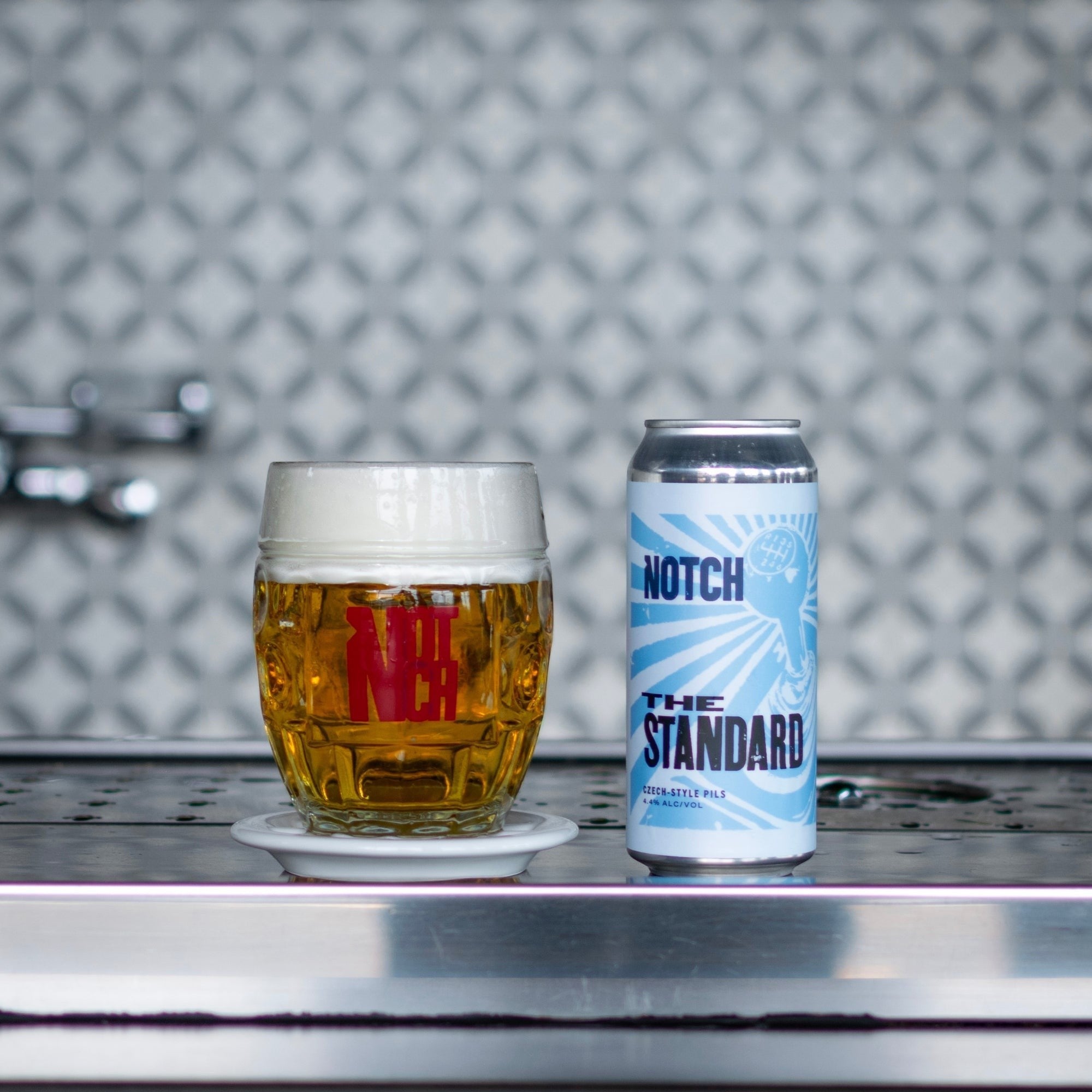 The Hocking Hills Store's The Standard Czech-style pale lager in a glass mug and can. Light golden beer with white foam.