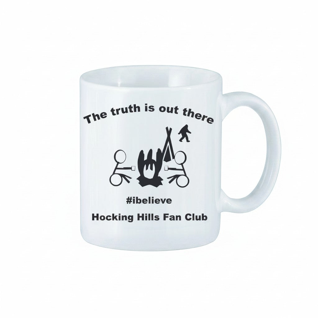 The Hocking Hills Store white ceramic mug with black text and graphics featuring a campfire, tent, Bigfoot, and the phrase "The truth is out there #ibelieve Hocking Hills Fan Club."
