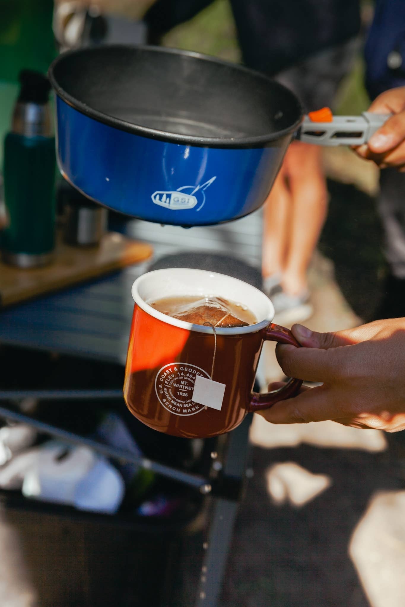 The Hocking Hills Store Wildland Coffee extra dark roast steepable coffee bag steeping in a red enamel mug.