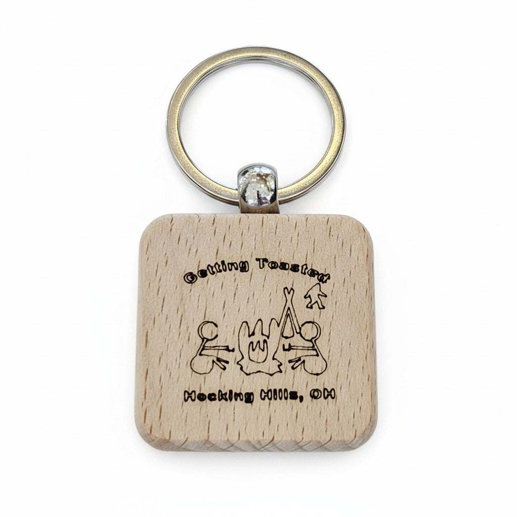 The Hocking Hills Store wooden keychain with laser engraved campfire scene and text "Getting Toasted Hocking Hills, OH".