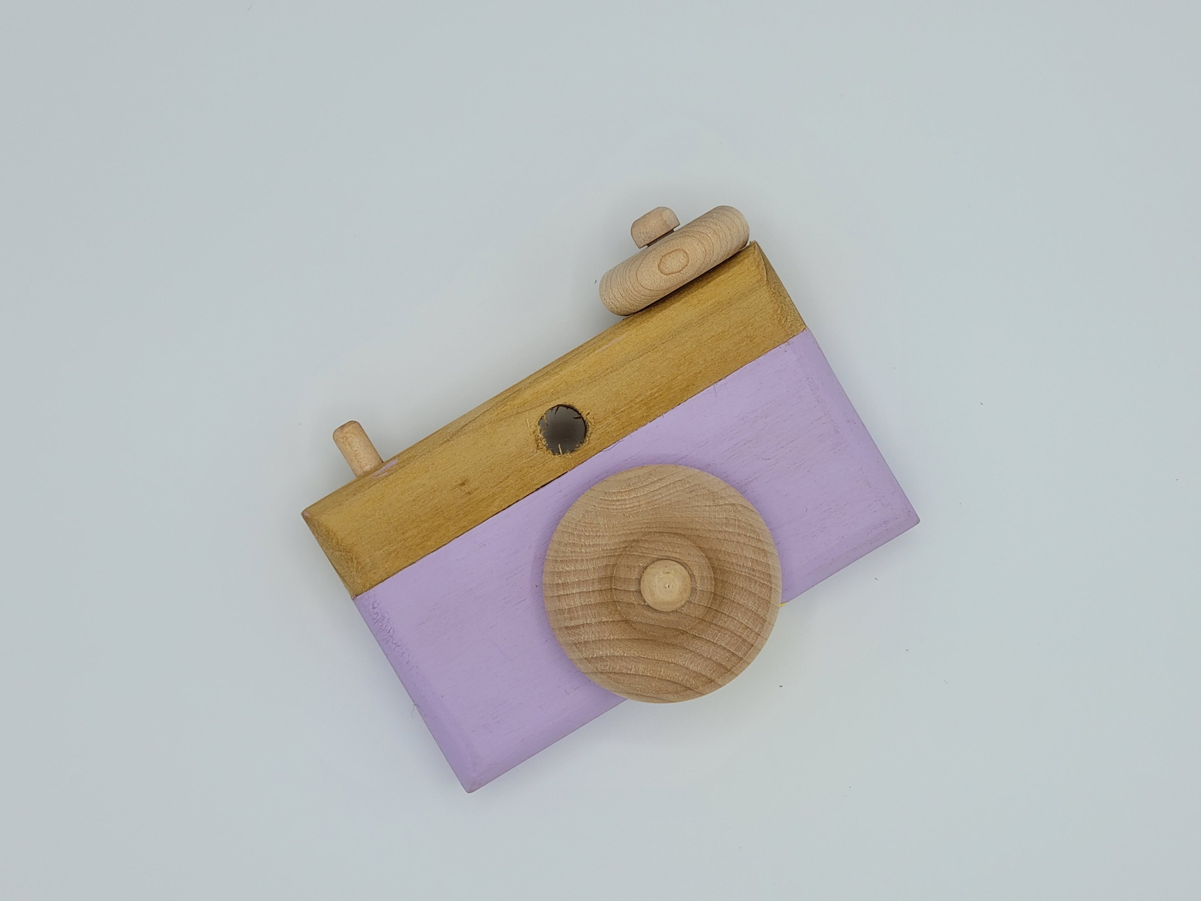 The Hocking Hills Store handmade wooden toy camera with lavender painted front and natural wood details.