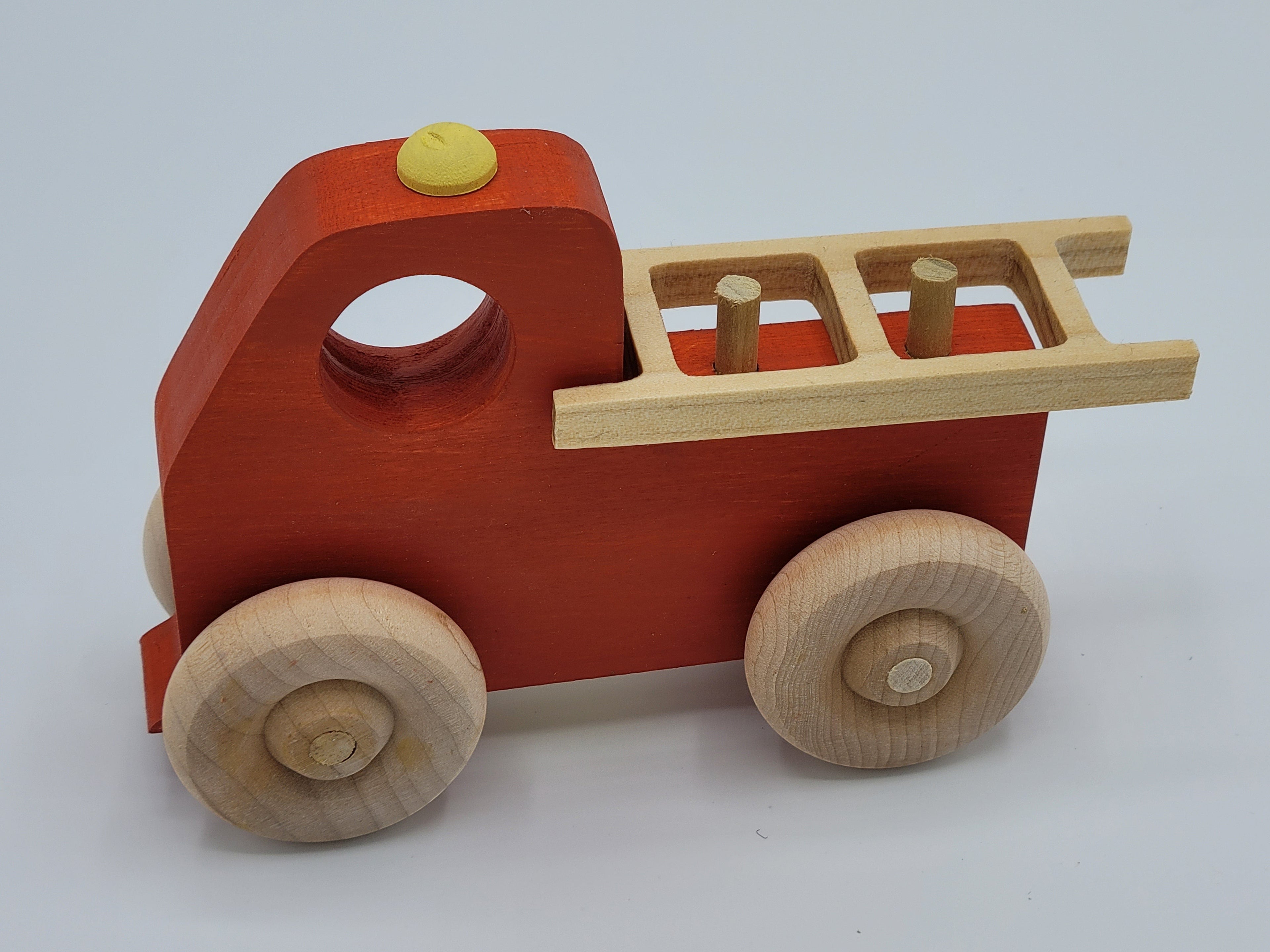The Hocking Hills Store handmade red wooden toy fire truck with natural wood wheels and ladder.