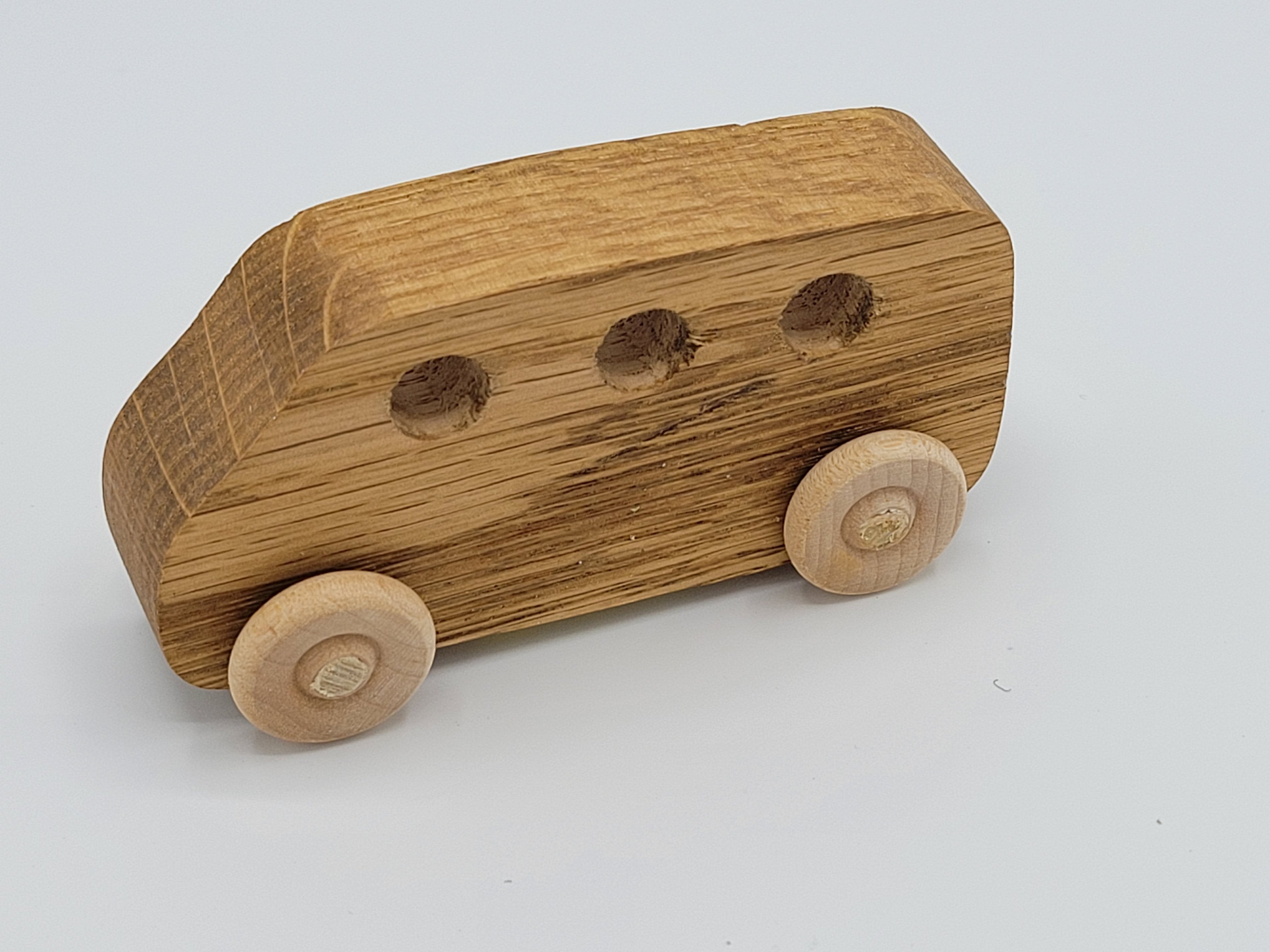 The Hocking Hills Store handmade wooden toy van with three circular windows and wooden wheels.
