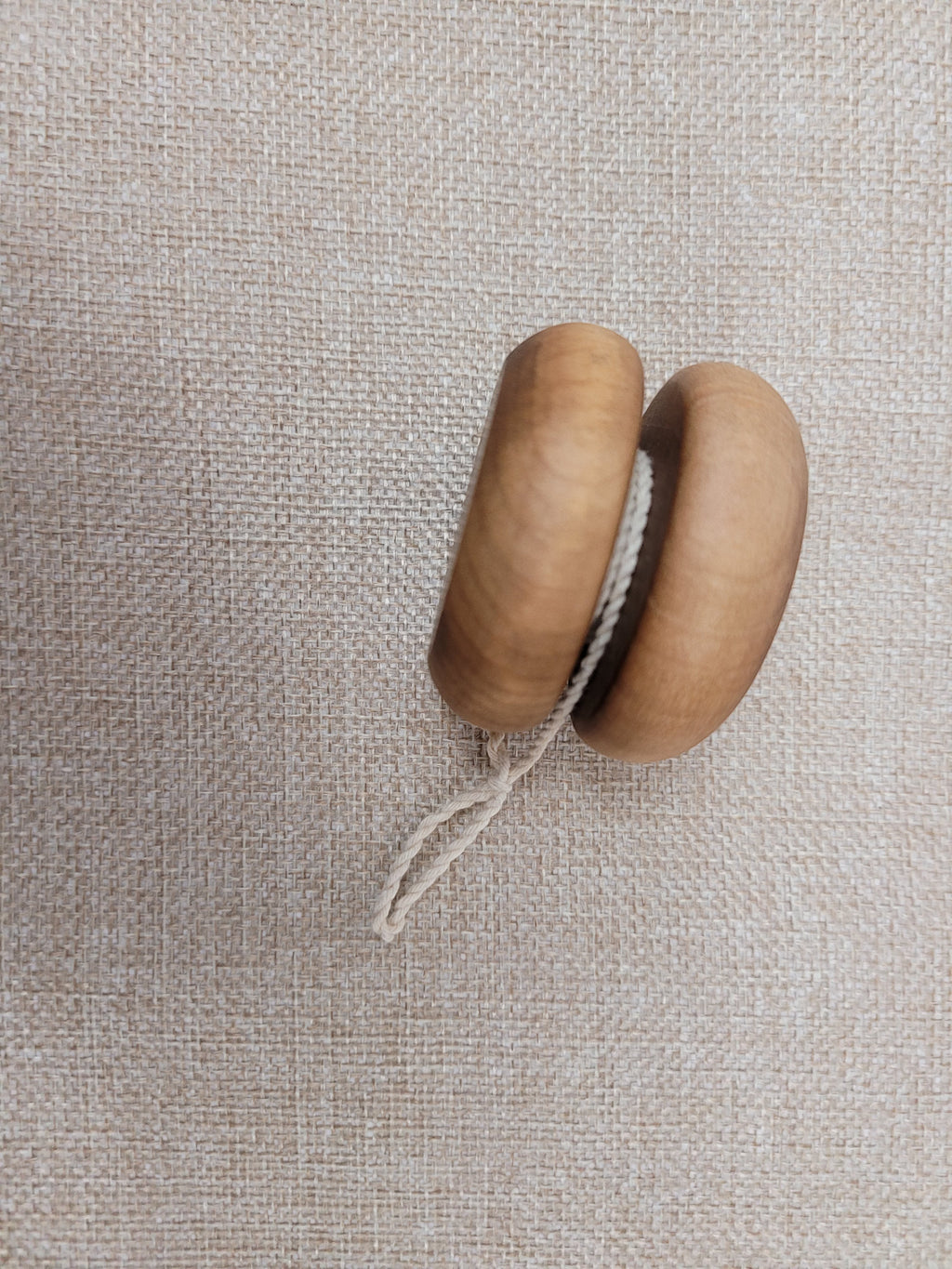 The Hocking Hills Store handmade wooden toy yo-yo with a natural wood finish and white string.