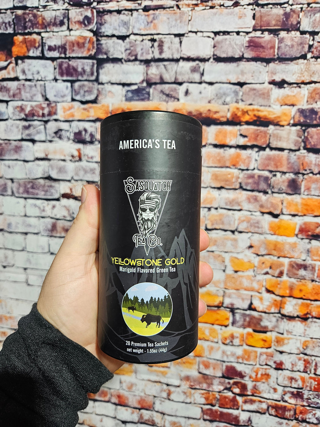 The Hocking Hills Store Sasquatch Tea Yellowstone Gold Marigold Flavored Green Tea in a black canister with bison and mountain graphics.